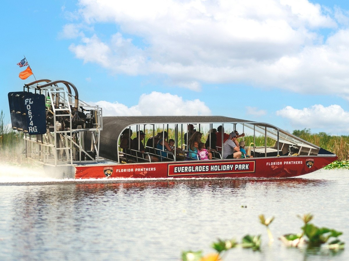 Airboat with passengers in Everglades Holiday Park on a sunny day.